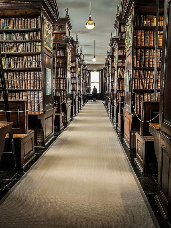 A long gallery of wooden bookcases inside Marsh’s Library