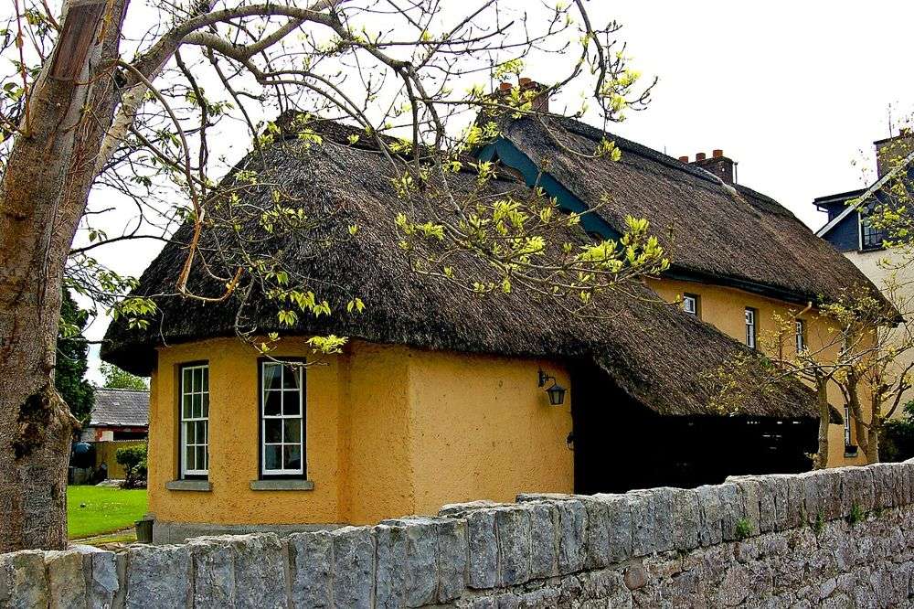 A yellow thatched cottage on Main Street in Adare