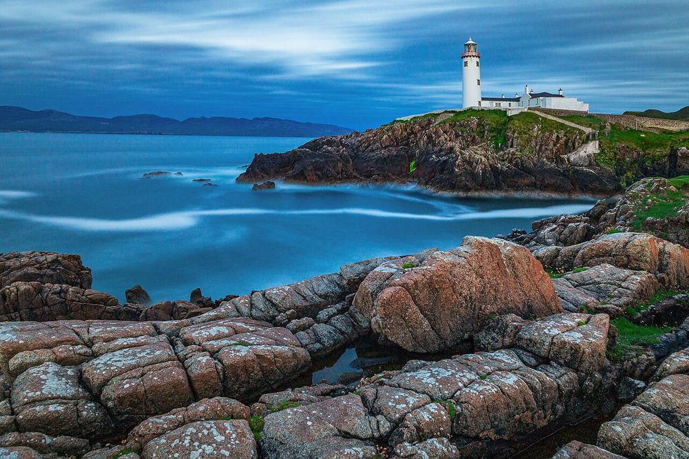 White lighthouse tower on Fanad Head’s rocky coast