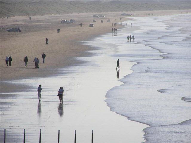 Walkers on the wide sandy beach at Portstewart Strand