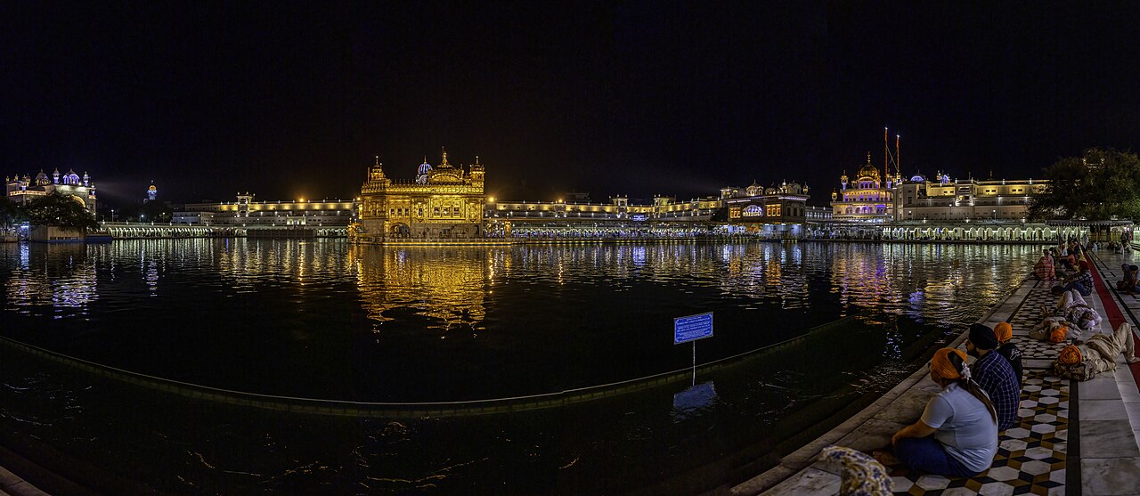 Sri Harmandir Sahib illuminated beside the water at night
